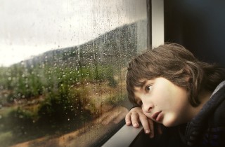 Infantil: niño triste mirando por la ventana
